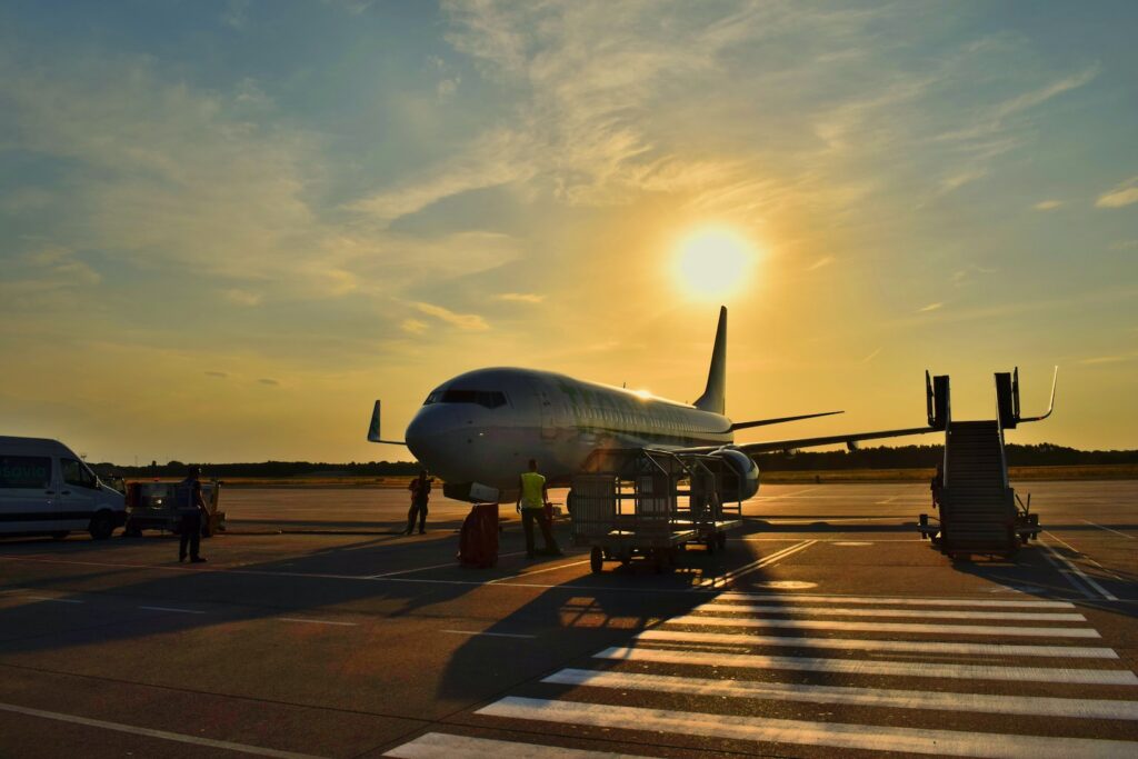 A plane is parked on the runway at sunset.